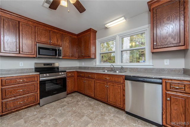 kitchen featuring stainless steel appliances, ceiling fan, and sink