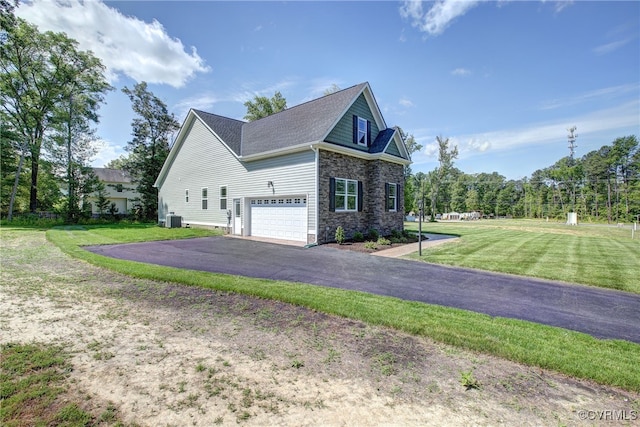 view of home's exterior featuring central AC unit, a garage, and a lawn