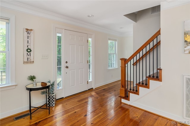 entryway with crown molding and hardwood / wood-style floors