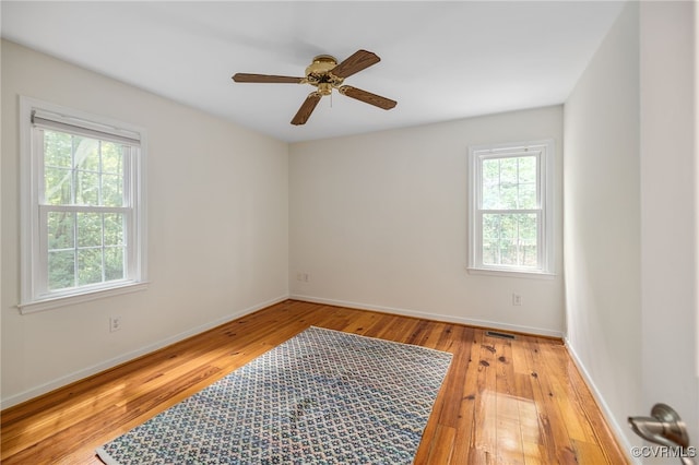 spare room with ceiling fan, light hardwood / wood-style flooring, and a healthy amount of sunlight