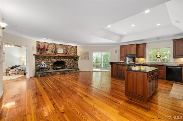 kitchen with a kitchen island, plenty of natural light, light hardwood / wood-style floors, and black appliances