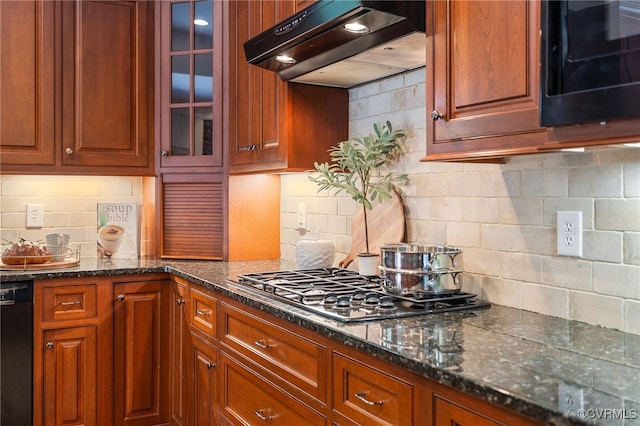 kitchen featuring decorative backsplash, dark stone counters, and black appliances