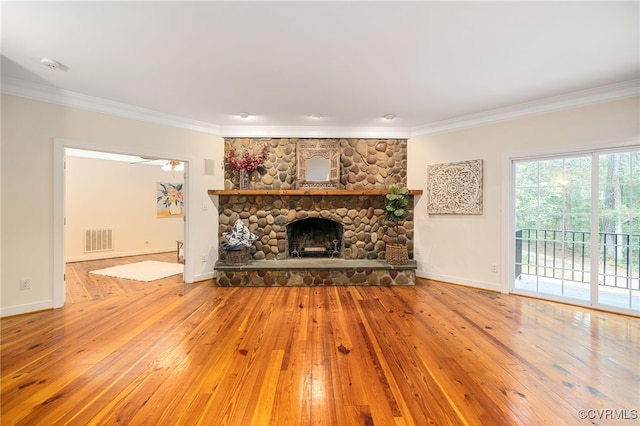 unfurnished living room featuring ornamental molding, a fireplace, ceiling fan, and hardwood / wood-style floors