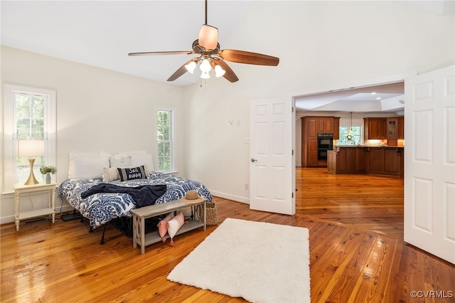 bedroom featuring hardwood / wood-style flooring, multiple windows, and ceiling fan