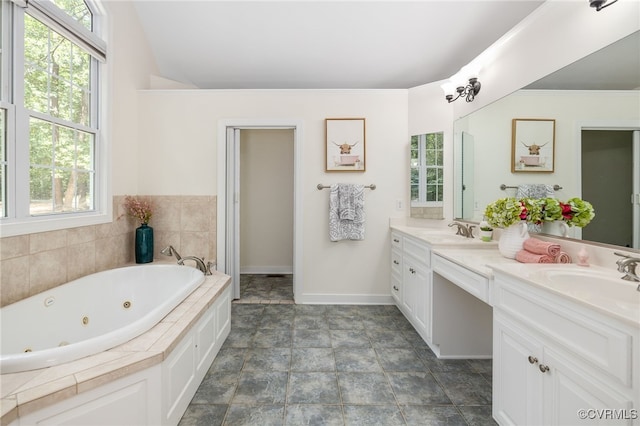 bathroom featuring tiled bath and vanity