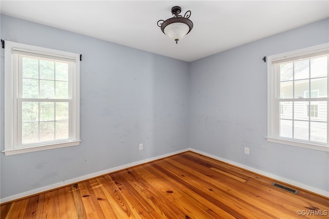 unfurnished room with a healthy amount of sunlight and wood-type flooring