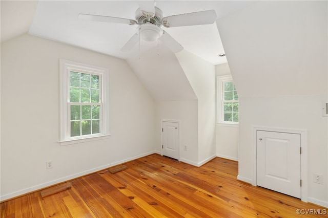 additional living space featuring a healthy amount of sunlight, ceiling fan, vaulted ceiling, and light hardwood / wood-style flooring