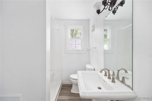 full bathroom featuring wood-type flooring, shower / bathtub combination, sink, and toilet