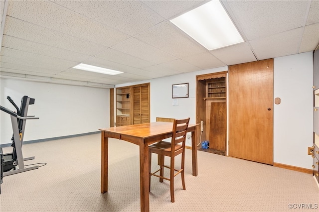 dining room featuring light carpet and a paneled ceiling