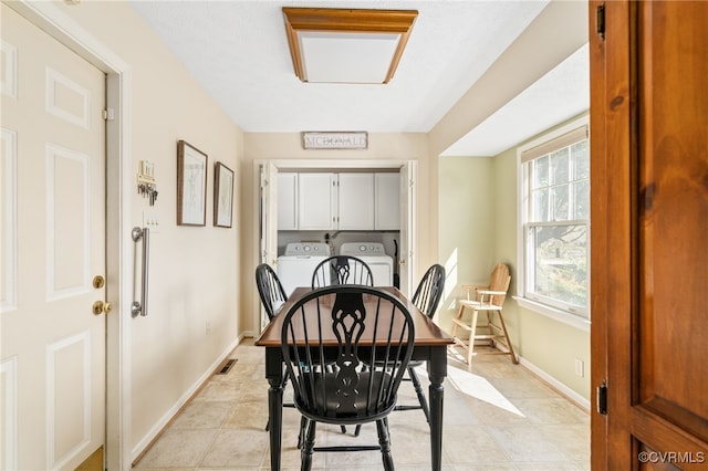 tiled dining area with separate washer and dryer