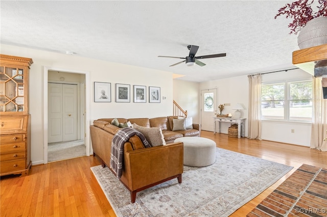 living room featuring hardwood / wood-style floors, a textured ceiling, and ceiling fan