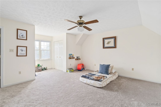 living area featuring a textured ceiling, vaulted ceiling, light colored carpet, and ceiling fan