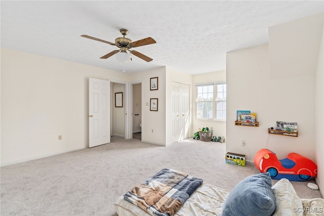 rec room with a textured ceiling, carpet flooring, and ceiling fan