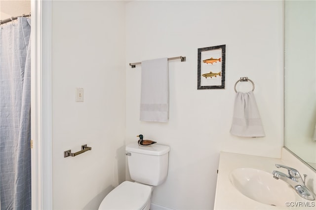 bathroom with toilet, vanity, and a shower with shower curtain