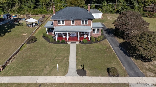 view of front of home featuring a gazebo, covered porch, and a front lawn