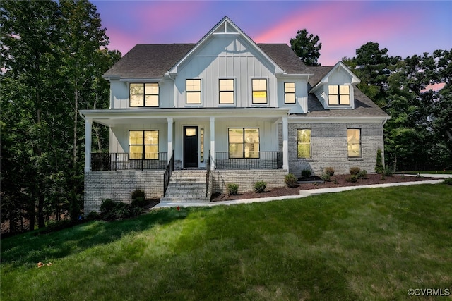 modern farmhouse with a yard and covered porch