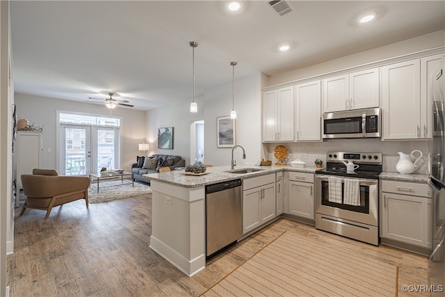 kitchen with white cabinets, appliances with stainless steel finishes, pendant lighting, and sink