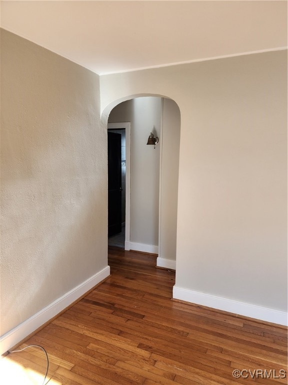 unfurnished room with dark wood-type flooring