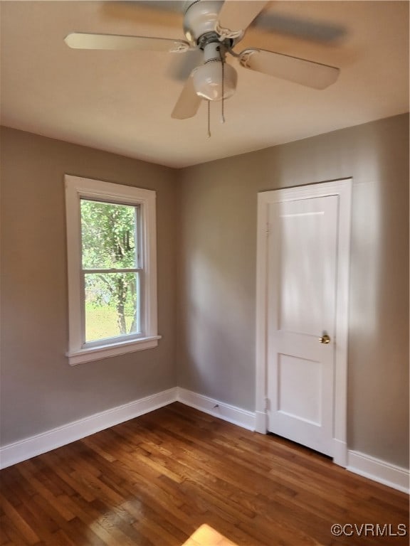 empty room with dark hardwood / wood-style flooring and ceiling fan