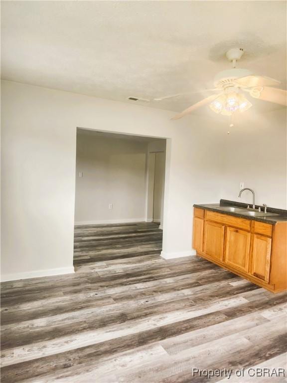 1934 Farley Park Rd, Middlesex, VA 23032 - kitchen with wood finished floors, dark countertops, ceiling fan, baseboards, and a sink