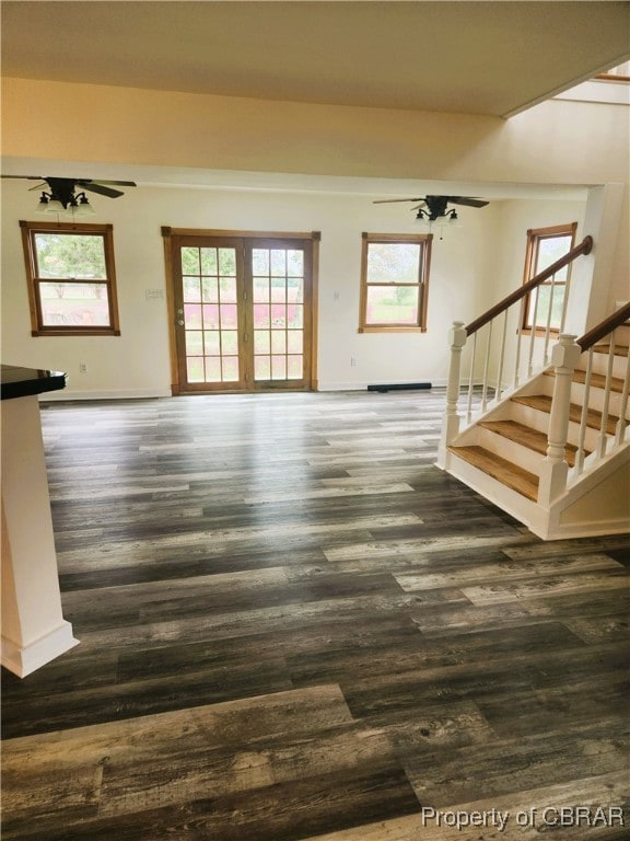 unfurnished living room featuring ceiling fan and dark hardwood / wood-style flooring