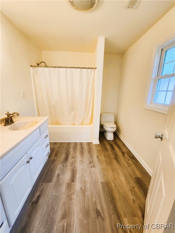 full bathroom with vanity, hardwood / wood-style floors, toilet, and shower / tub combo