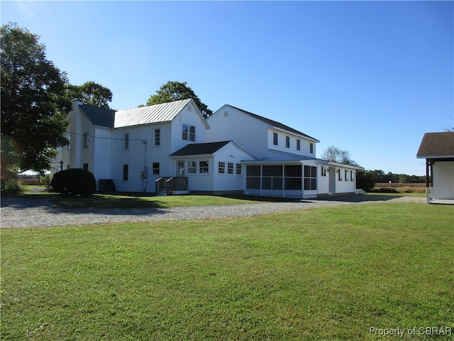 back of house featuring a sunroom and a yard