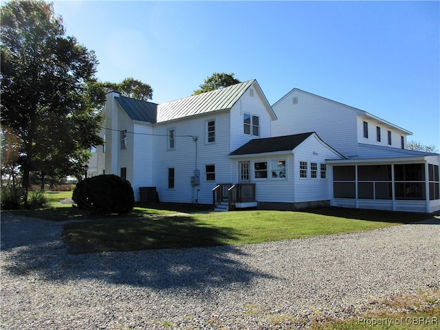 back of house with a sunroom and a yard