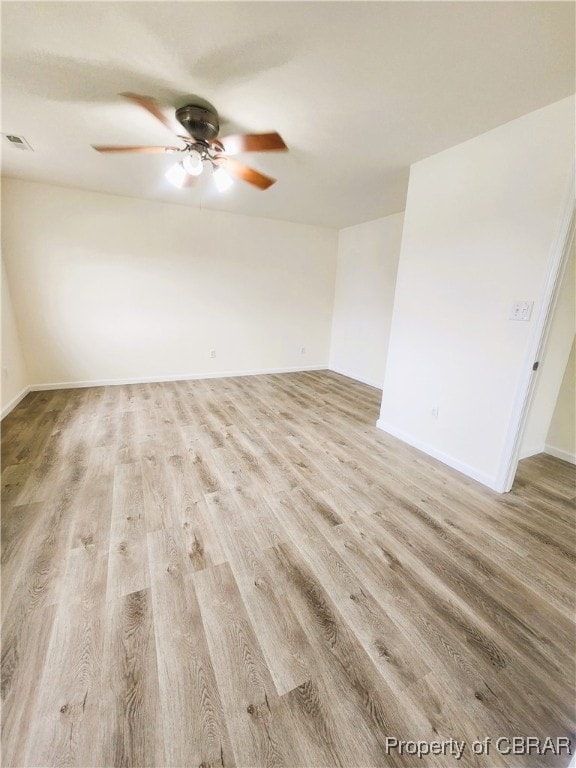 empty room with ceiling fan and light hardwood / wood-style flooring