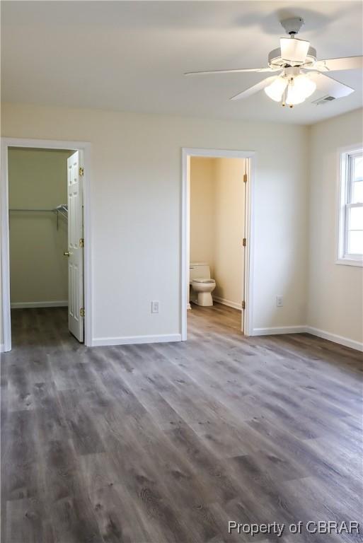 1934 Farley Park Rd, Middlesex, VA 23032 - unfurnished bedroom with baseboards, dark wood finished floors, a spacious closet, and connected bathroom
