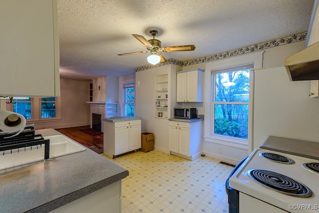 kitchen with ceiling fan, white cabinets, extractor fan, white range with electric cooktop, and a textured ceiling