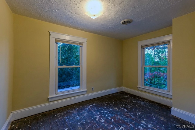 unfurnished room featuring a textured ceiling