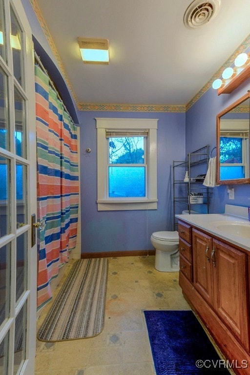 bathroom with walk in shower, vanity, and toilet