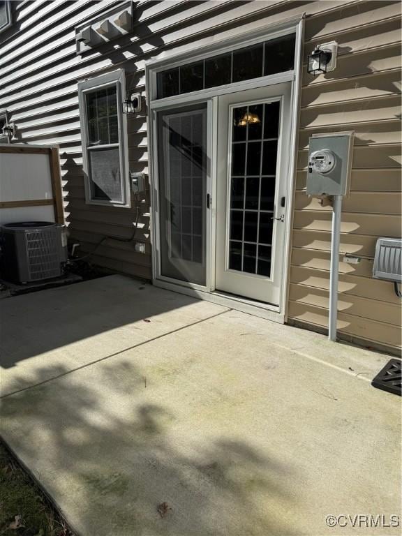 entrance to property with central air condition unit and a patio area