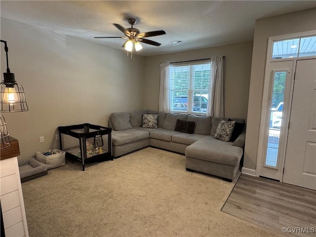 living area with visible vents, ceiling fan, and wood finished floors