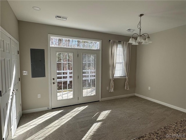 doorway to outside featuring a chandelier, electric panel, and dark carpet