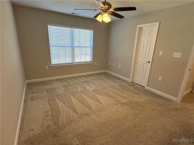 empty room featuring baseboards, visible vents, ceiling fan, and carpet flooring