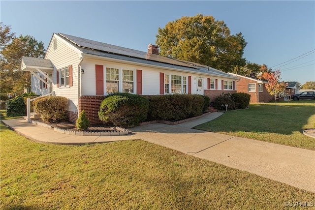 ranch-style home with solar panels and a front yard