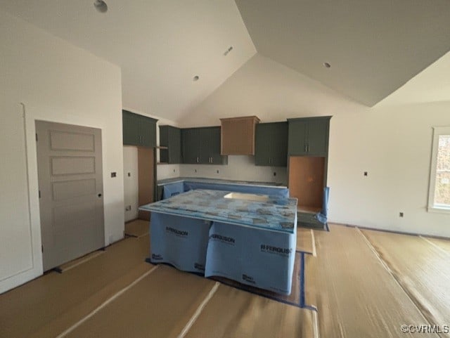 kitchen with light wood-type flooring, high vaulted ceiling, and a center island