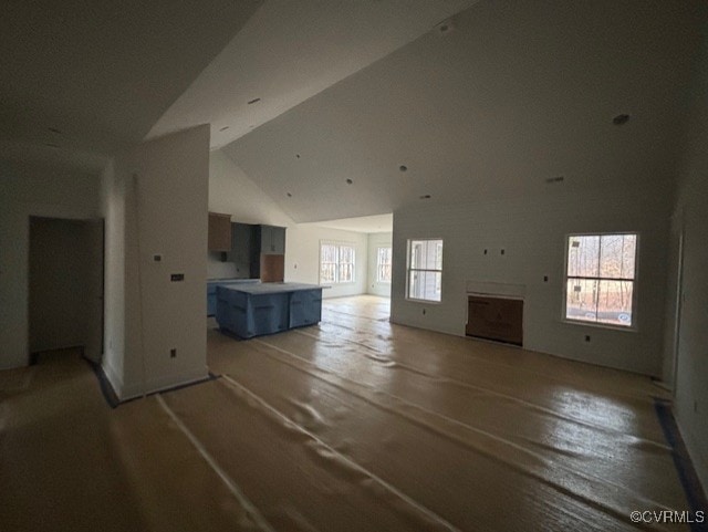 unfurnished living room with high vaulted ceiling