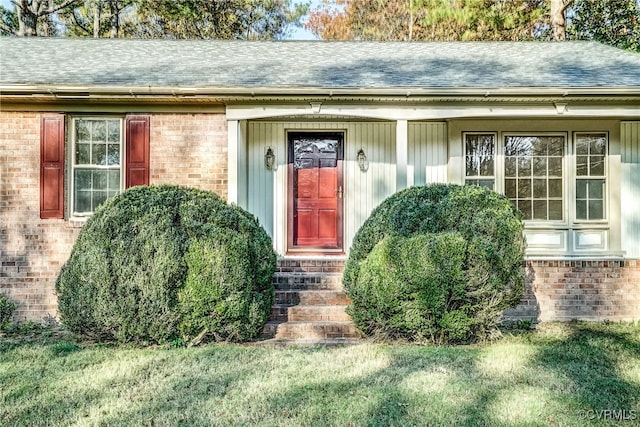 view of exterior entry with a yard