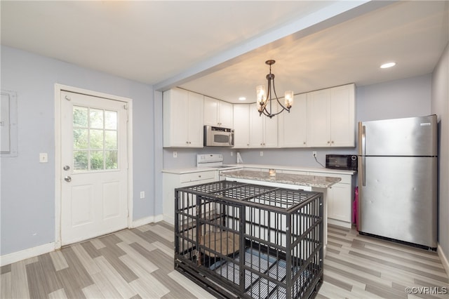 kitchen with stainless steel appliances, pendant lighting, and white cabinets