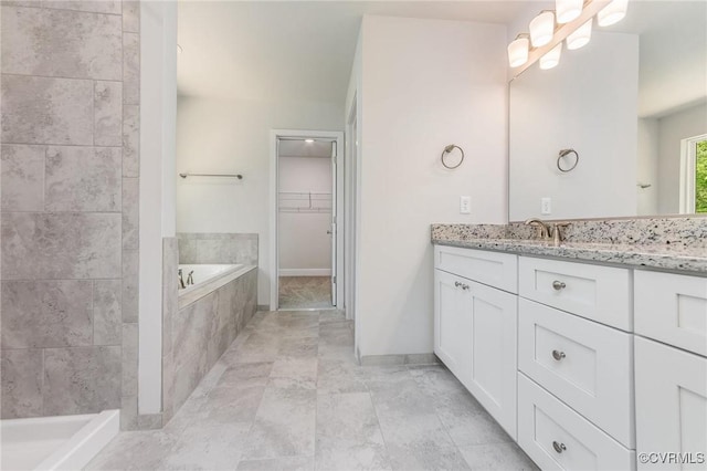 bathroom featuring vanity and tiled bath