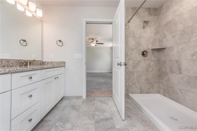 bathroom featuring vanity, ceiling fan, and a tile shower