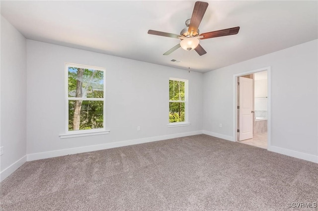 carpeted spare room with a wealth of natural light and ceiling fan