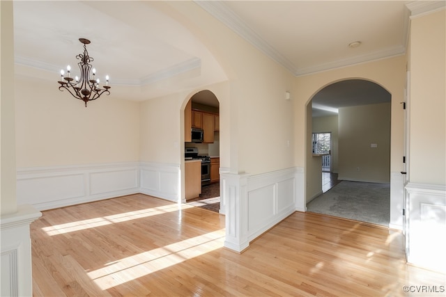 interior space featuring light hardwood / wood-style floors, crown molding, and an inviting chandelier