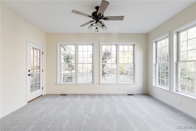 unfurnished sunroom with ceiling fan