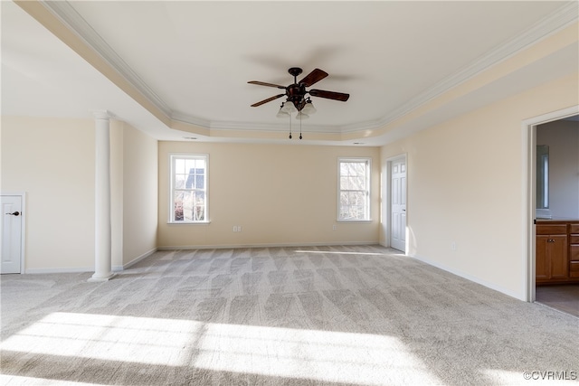 carpeted spare room with a raised ceiling, ceiling fan, a healthy amount of sunlight, and crown molding