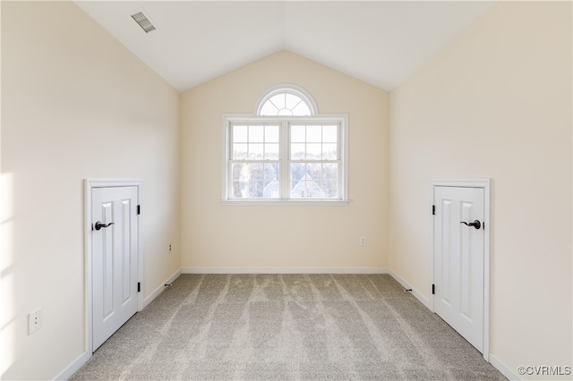 unfurnished room featuring light colored carpet and vaulted ceiling