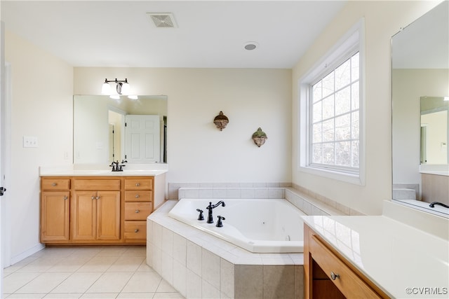 bathroom with tiled bath, tile patterned flooring, and vanity